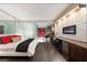 Modern bedroom with stone accent wall, electric fireplace, desk, and a comfortable king bed with mirrored wall feature at 4381 W Flamingo Rd # 24304, Las Vegas, NV 89103