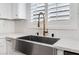 Close up of the stainless steel farmhouse sink and gold-colored faucet in the kitchen at 5537 Sentinel Bridge St, Las Vegas, NV 89130