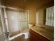 Bathroom featuring a glass enclosed shower-tub combo, vanity, and toilet at 5576 W Rochelle Ave # 38B, Las Vegas, NV 89103
