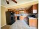 Functional kitchen with wood cabinets, black appliances, and a backsplash at 5576 W Rochelle Ave # 38B, Las Vegas, NV 89103