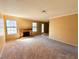 Bright living room featuring a brick fireplace, soft carpet, and ample natural light at 5576 W Rochelle Ave # 38B, Las Vegas, NV 89103