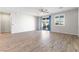 Bright living room with wood-look tile flooring, ceiling fan, and sliding glass doors to the backyard at 6033 Torciano St, North Las Vegas, NV 89081