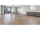 Spacious living room with wood-look tile flooring, a ceiling fan, and adjacent cabinetry at 6033 Torciano St, North Las Vegas, NV 89081