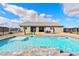 Sparkling pool with stone coping surrounded by patio area, xeriscaping, and home exterior at 6101 Cavalry Trl, Pahrump, NV 89060