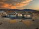 Charming single-story home with a three-car garage, desert landscaping, and mountain views at sunset at 6101 Cavalry Trl, Pahrump, NV 89060