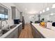 Modern kitchen featuring gray cabinets, a spacious island, and stainless steel appliances overlooking the living area at 6101 Cavalry Trl, Pahrump, NV 89060
