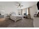 Serene main bedroom with a ceiling fan, carpet flooring, and an en-suite bathroom at 6101 Cavalry Trl, Pahrump, NV 89060