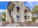Exterior view with private stairway entrance with blue awnings, tile roof, and manicured landscaping at 6109 W Oakey Blvd # C, Las Vegas, NV 89146