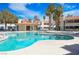 Community pool view featuring palm trees, lounge seating, clear blue water, and surrounding buildings under a bright blue sky at 6109 W Oakey Blvd # C, Las Vegas, NV 89146