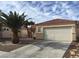 Exterior showcasing a low-maintenance desert landscape, red-tiled roof, and an attached two-car garage at 6119 Magic Mesa St, North Las Vegas, NV 89031