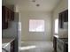 Bright kitchen area featuring tiled floors, dark cabinetry, white appliances, and lots of natural light at 6119 Magic Mesa St, North Las Vegas, NV 89031