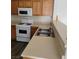 Kitchen featuring double-basin sink, wood cabinets, white appliances, and laminate countertop at 6425 Extreme Shear Ave # 101, Henderson, NV 89011
