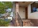 Welcoming front porch with brick accents and a wrought-iron railing provides a charming entry to the home at 664 Sky Rd, Indian Springs, NV 89018