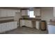 Spacious kitchen with white cabinets, tan countertops, stainless steel sink, and wood flooring for a modern look at 664 Sky Rd, Indian Springs, NV 89018