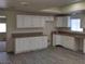 Bright kitchen with white cabinets, tan countertops, stainless steel sink, and wood flooring; adjacent to another room at 664 Sky Rd, Indian Springs, NV 89018