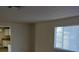 Cozy living room with neutral paint, a window with blinds, and partial view of the cabinets and countertops of the kitchen at 664 Sky Rd, Indian Springs, NV 89018