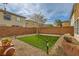 Backyard features a grassy area, desert landscaping, privacy wall, and a mature tree at 6655 Little Owl Pl, North Las Vegas, NV 89084