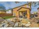 Inviting backyard with a stone fire pit, patio seating, and green lawn, ideal for entertaining at 6655 Little Owl Pl, North Las Vegas, NV 89084