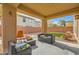 Covered patio with furniture in backyard with stone accents, desert landscaping at 6655 Little Owl Pl, North Las Vegas, NV 89084