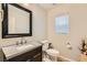 Stylish powder bathroom featuring a granite vanity, modern faucet, and framed mirror at 6655 Little Owl Pl, North Las Vegas, NV 89084