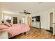 Bright bedroom with wood floors, a ceiling fan, and a TV with stylish decor at 6655 Little Owl Pl, North Las Vegas, NV 89084