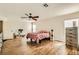 Well-lit bedroom with wood floors, ceiling fan, dresser, and ample closet space at 6655 Little Owl Pl, North Las Vegas, NV 89084