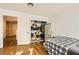 Well-lit bedroom featuring hardwood floors, a fan, and a closet with ample storage space near doorway at 6655 Little Owl Pl, North Las Vegas, NV 89084