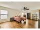 Spacious bedroom with wood floors, a ceiling fan, and abundant natural light from multiple windows at 6655 Little Owl Pl, North Las Vegas, NV 89084