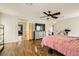 Spacious bedroom with wood floors, a ceiling fan, with a view to the bathroom and hallway at 6655 Little Owl Pl, North Las Vegas, NV 89084