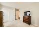 Bright bedroom features carpet, a wall-mounted TV, modern wood dressers and sliding closet doors at 6655 Little Owl Pl, North Las Vegas, NV 89084
