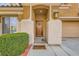 Close up of the decorative wooden front door with a covered front porch and desert landscaping at 6655 Little Owl Pl, North Las Vegas, NV 89084