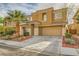 Two-story home with a desert landscape, two car garage and a covered front porch and mature palm tree at 6655 Little Owl Pl, North Las Vegas, NV 89084