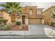Two-story home with a desert landscape, two car garage and a covered front porch and mature palm tree at 6655 Little Owl Pl, North Las Vegas, NV 89084
