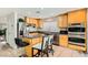 Bright kitchen featuring stainless steel appliances, wooden cabinets, and a center island with seating at 6655 Little Owl Pl, North Las Vegas, NV 89084
