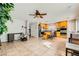 Open-concept living room featuring tile floors, neutral walls, and a kitchen island with bar seating at 6655 Little Owl Pl, North Las Vegas, NV 89084