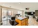 Bright living room featuring a kitchen island, sliding glass door, and tile flooring at 6655 Little Owl Pl, North Las Vegas, NV 89084