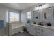 Well-lit bathroom with double sinks, a soaking tub, and modern fixtures at 6924 Ghost Ranch Ave, Las Vegas, NV 89179