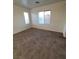 A light-filled bedroom with neutral walls, carpet flooring, and two windows to bring in natural light at 731 Emerald Idol Pl, Henderson, NV 89011