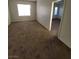 A bedroom with neutral walls, carpet flooring, and a large window, creating a serene and inviting atmosphere at 731 Emerald Idol Pl, Henderson, NV 89011