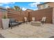 Cozy backyard space with modern privacy fence, fire pit, stone patio, and comfortable seating at 765 Crimson Peak Pl, Henderson, NV 89011