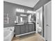 Bathroom featuring double sink vanity, soaking tub, wood-look flooring, and modern lighting at 765 Crimson Peak Pl, Henderson, NV 89011