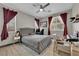 Comfortable bedroom with a ceiling fan, plush bedding, and a large sunny window at 765 Crimson Peak Pl, Henderson, NV 89011
