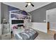 Bedroom featuring a house-frame bunk bed with a galaxy-themed accent wall and neutral-colored carpet at 765 Crimson Peak Pl, Henderson, NV 89011