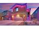 Charming two-story home featuring a brick driveway, desert landscaping, and festive holiday lighting at 765 Crimson Peak Pl, Henderson, NV 89011