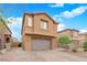 Charming two-story home featuring a brick driveway, desert landscaping, and an attached garage at 765 Crimson Peak Pl, Henderson, NV 89011