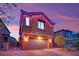 Charming two-story home featuring a brick driveway, desert landscaping, and festive holiday lighting at 765 Crimson Peak Pl, Henderson, NV 89011