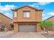 Two-story home with a brick driveway, two-car garage, landscaped yard, and well-maintained exterior at 765 Crimson Peak Pl, Henderson, NV 89011