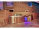 Built-in stainless steel outdoor kitchen with sink, grill, refrigerator with beverage lights and stone tile flooring at 765 Crimson Peak Pl, Henderson, NV 89011