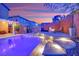 Backyard swimming pool, fire pit, privacy fence, stone terrace and outdoor seating at sunset at 765 Crimson Peak Pl, Henderson, NV 89011