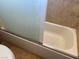 A close-up view of a bathtub with sliding glass doors and tile walls at 7732 Blackbird Ave, Las Vegas, NV 89145